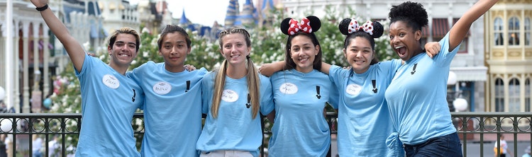 Six students posing near Main Street, U.S.A. at Magic Kingdom park